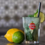 A variety of colorful and refreshing homemade mojitos garnished with fresh fruits and mint leaves.